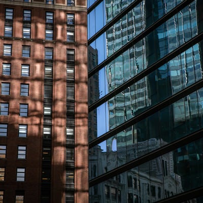 ガラス張りの窓に映りこむニューヨークの建物の写真