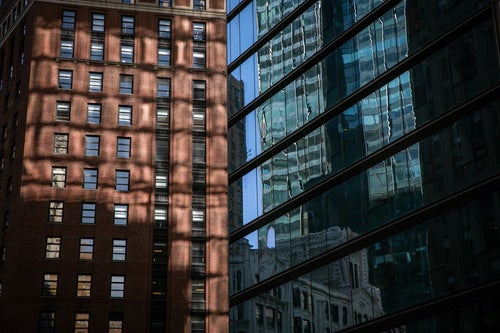 ガラス張りの窓に映りこむニューヨークの建物の写真