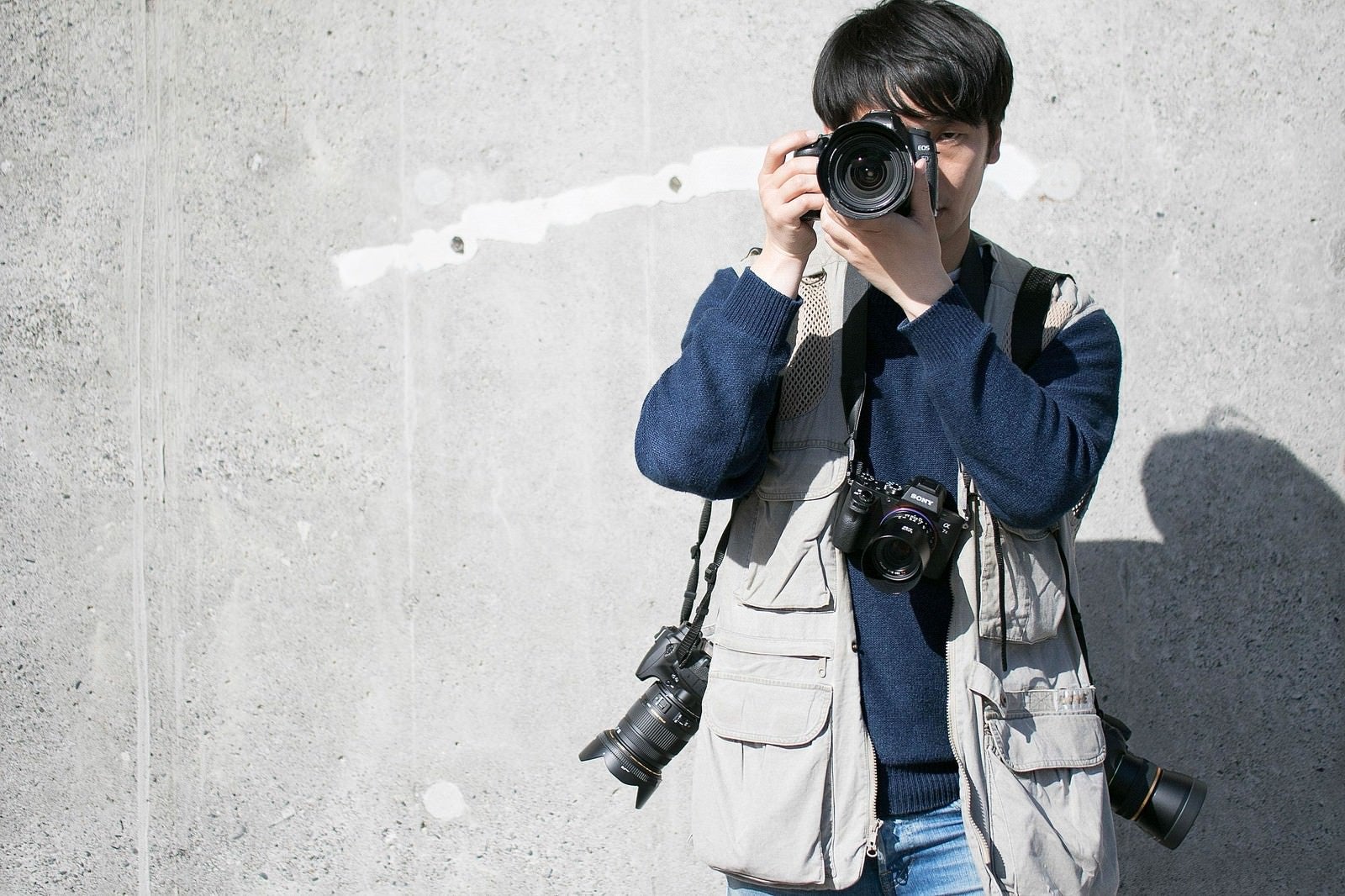 「複数台のカメラでガチ装備する報道」の写真［モデル：大川竜弥］