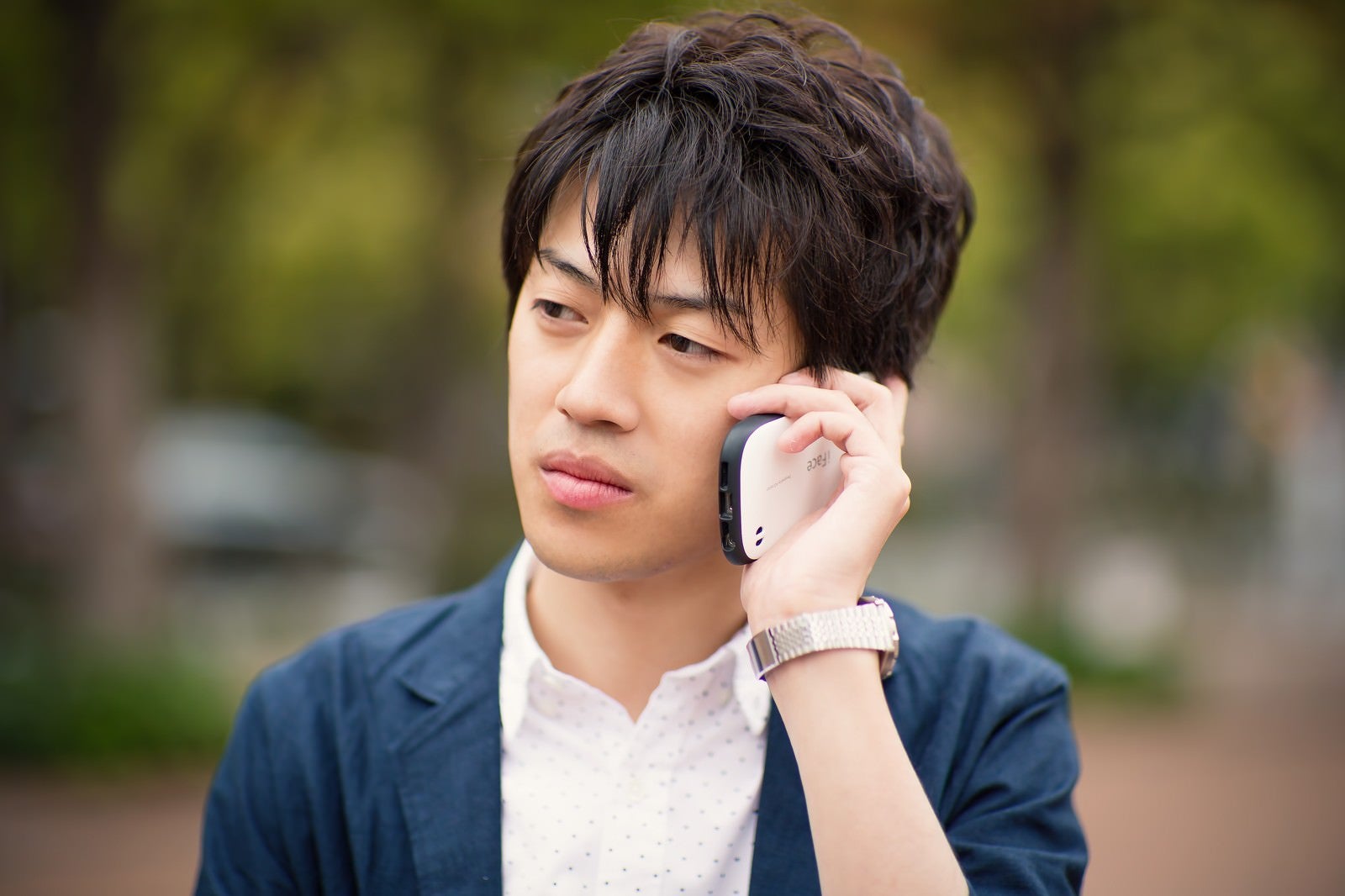 「電話で恋人に別れ話を告げられる男性」の写真［モデル：Tsuyoshi.］