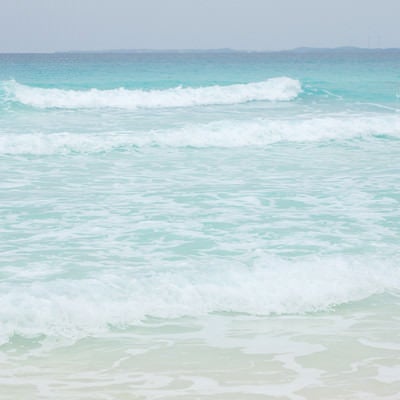 エメラルドグリーンの海と波の写真