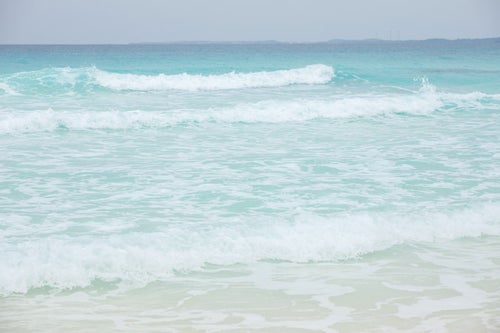 エメラルドグリーンの海と波の写真