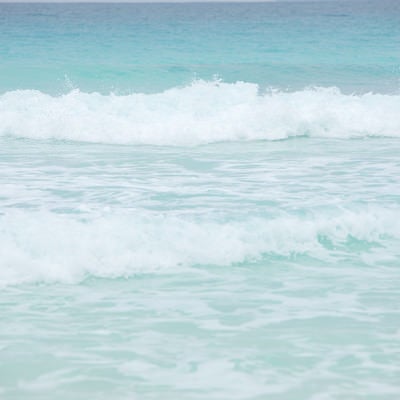 エメラルドの海と波しぶきの写真