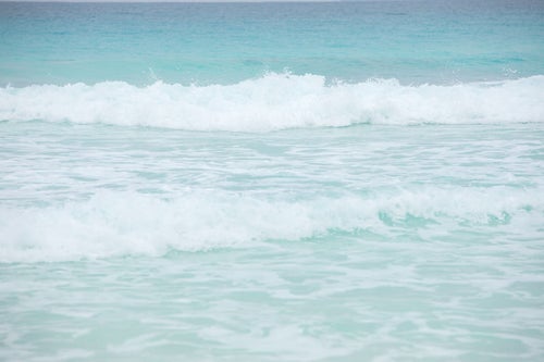 エメラルドの海と波しぶきの写真