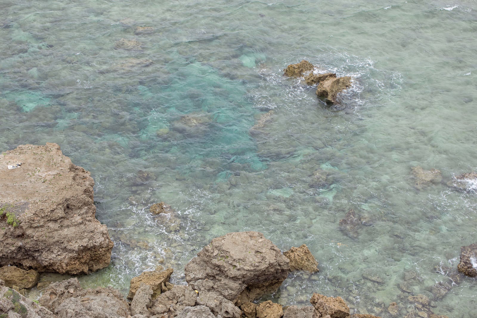 「ゴツゴツした岩場と透き通る海」の写真