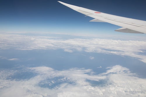 旅客機の翼と上空から見える景色の写真
