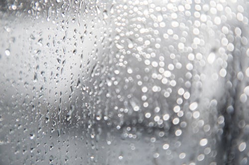 窓につく雨の水滴の写真