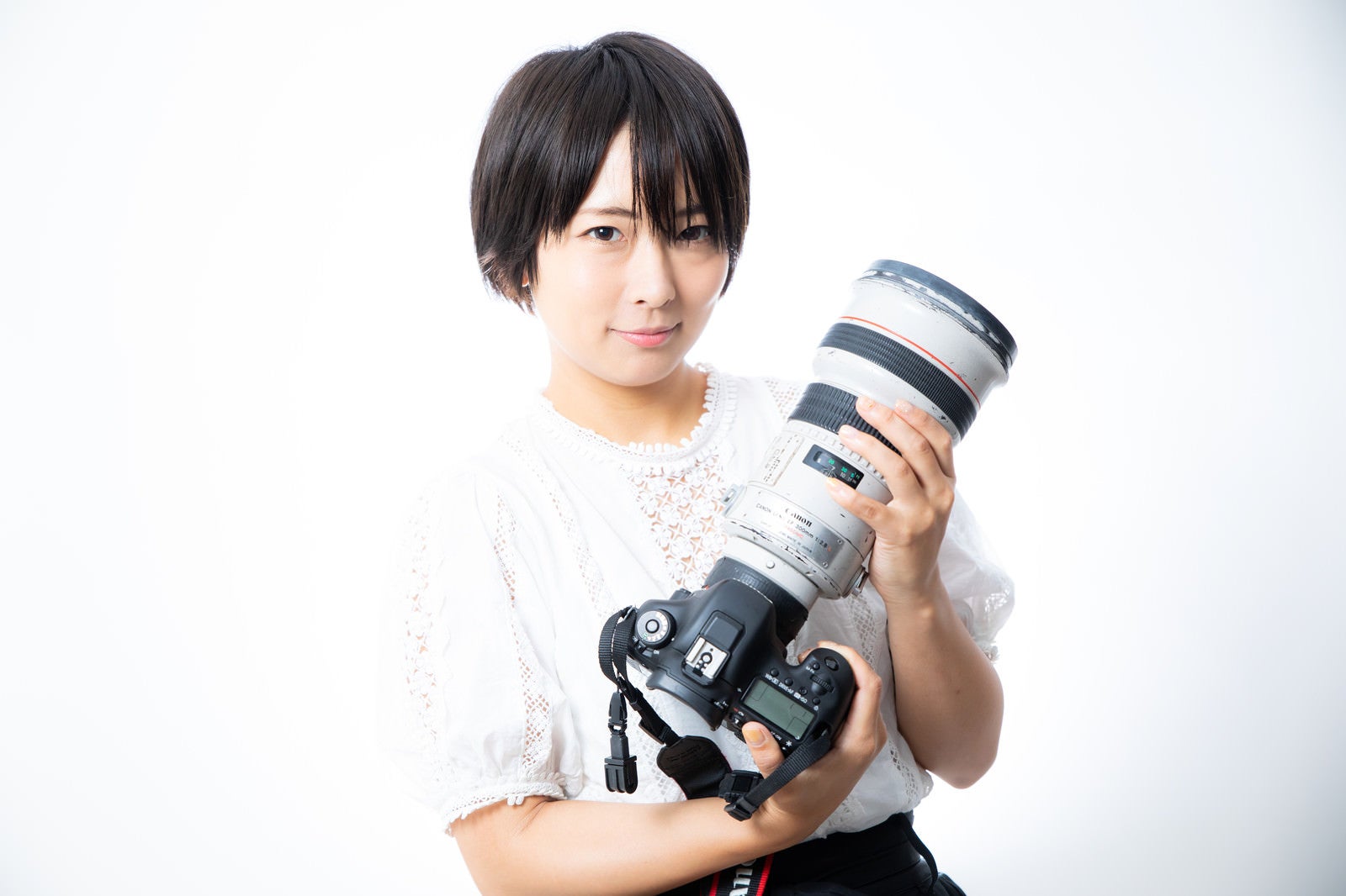 「300mmの白レンズを抱える女性」の写真［モデル：にゃるる］