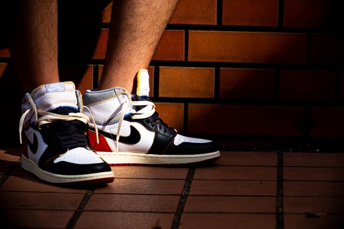 スニーカーを履いた足元に差し込む光(AIR JORDAN)の写真