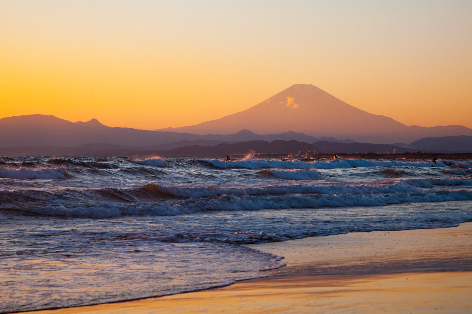 「押し寄せる波と富士の山」の写真