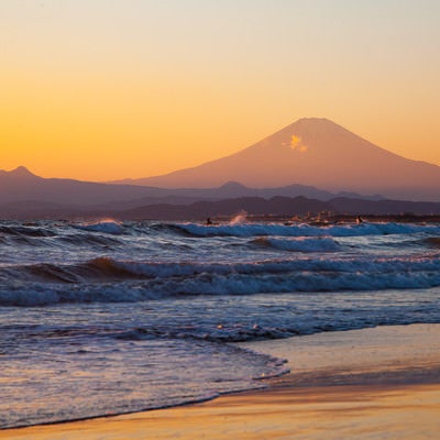 押し寄せる波と富士の山の写真
