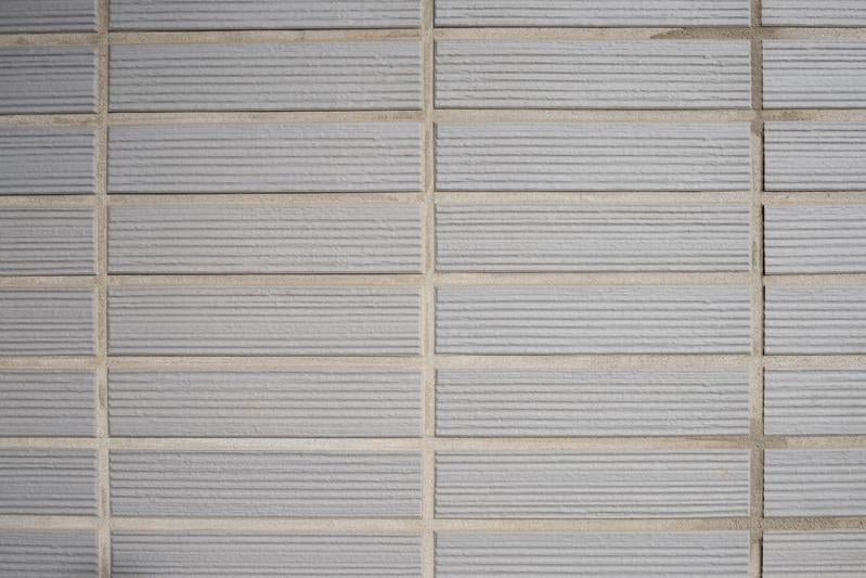 横縞模様が入ったグレーのタイル壁の写真