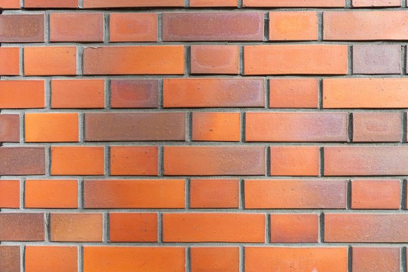 温かみのあるオレンジ色のレンガブロックで作られた壁の写真