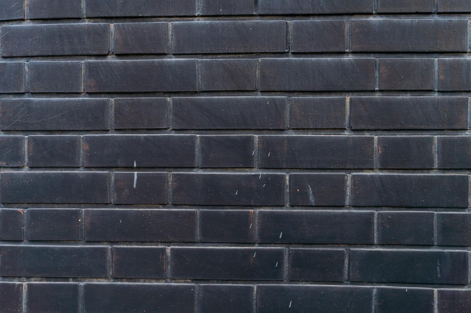 整然と積み上げられた黒いレンガの壁面テクスチャ