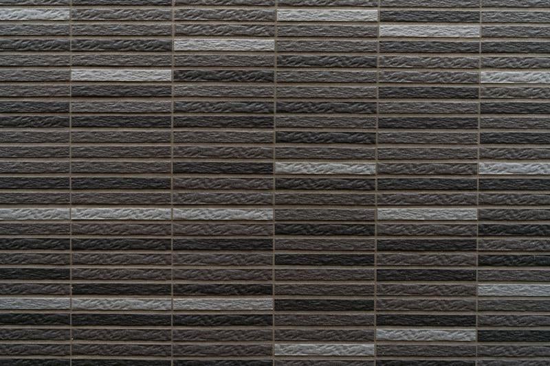 ダークブラウンとライトグレーの横長レンガタイルの写真