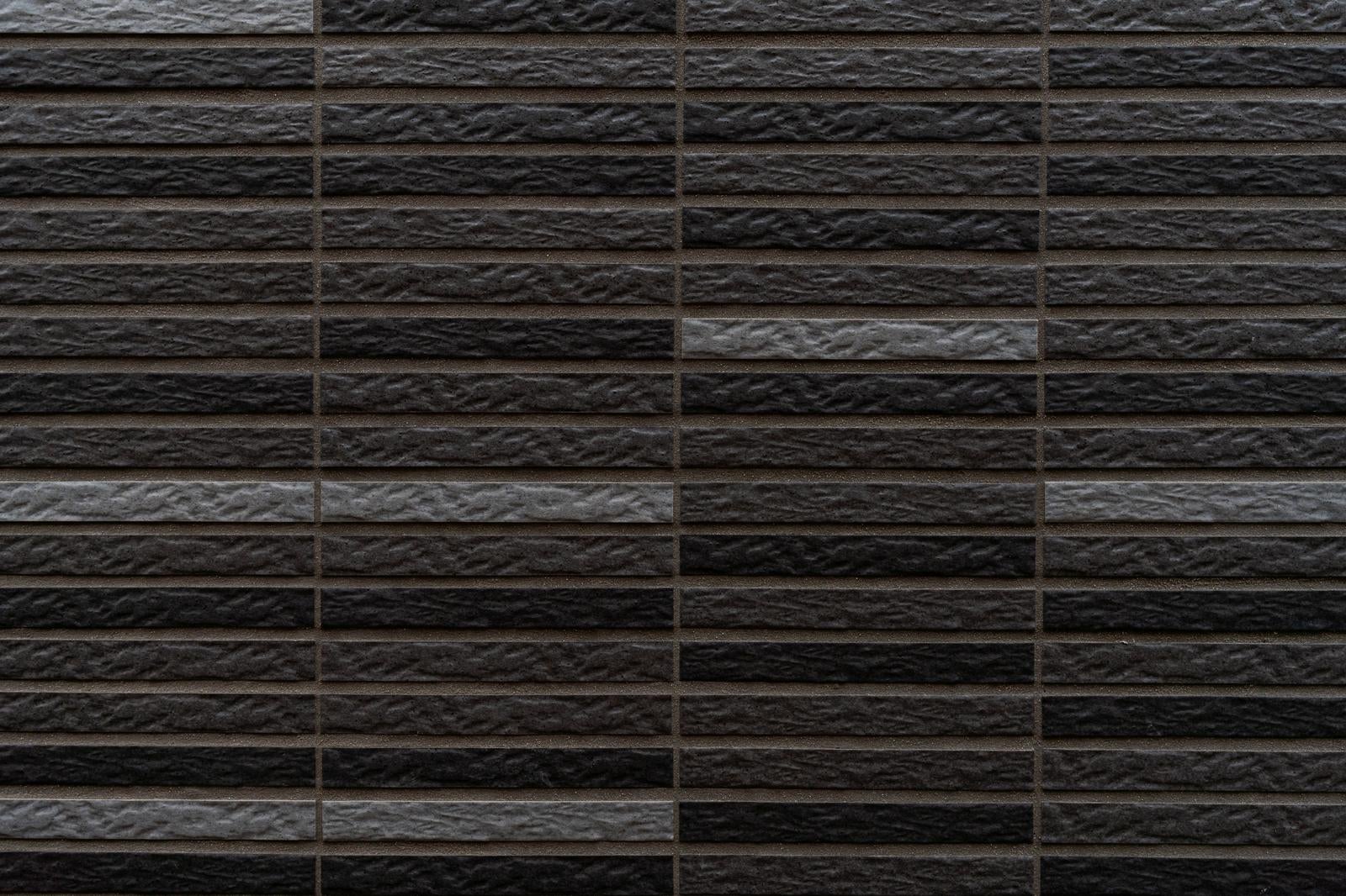 黒とグレーの濃淡があるレンガ調外壁のテクスチャー