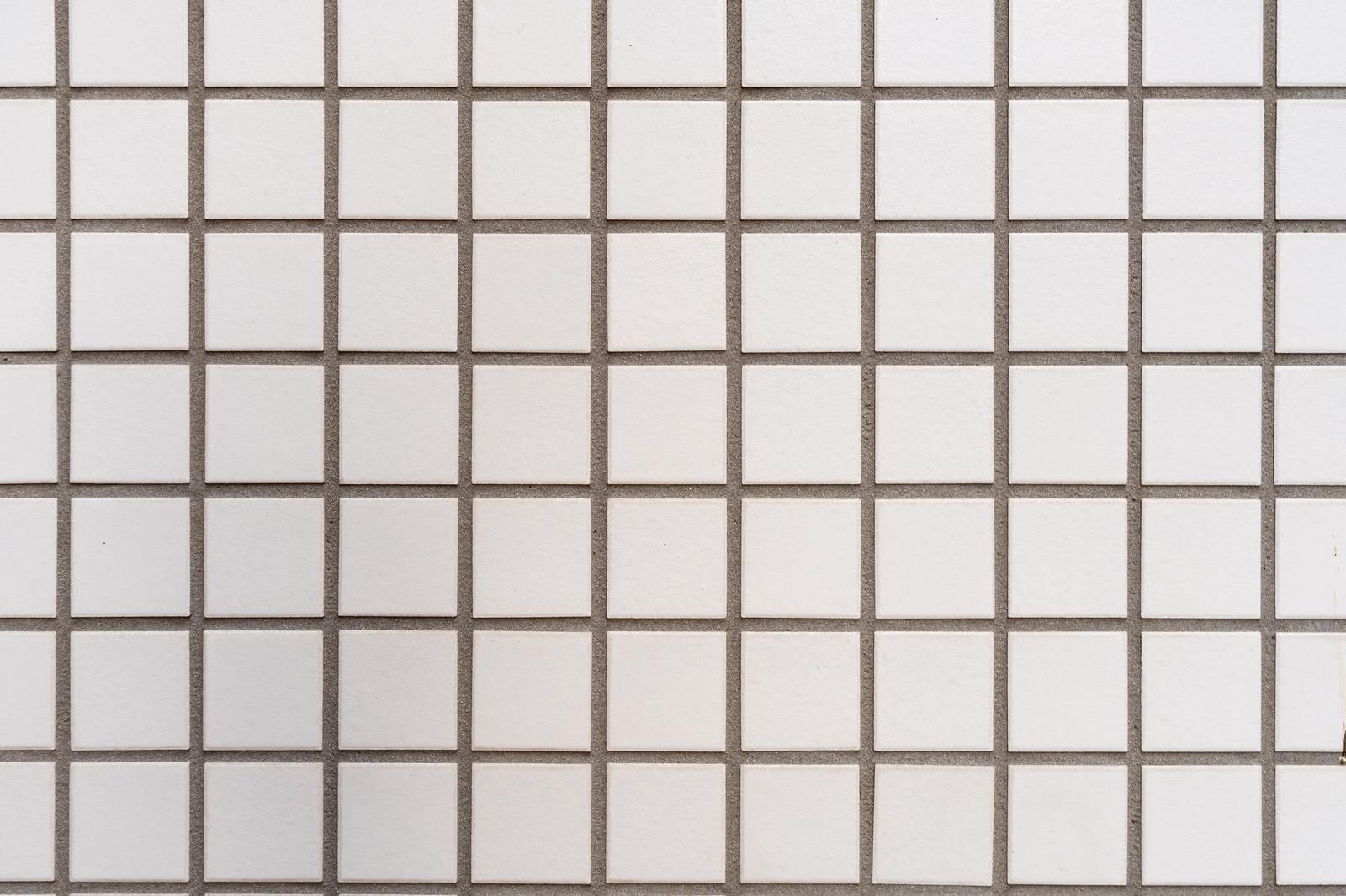 グレーの目地で区切られた白い正方形タイルが規則的に並ぶ格子パターン