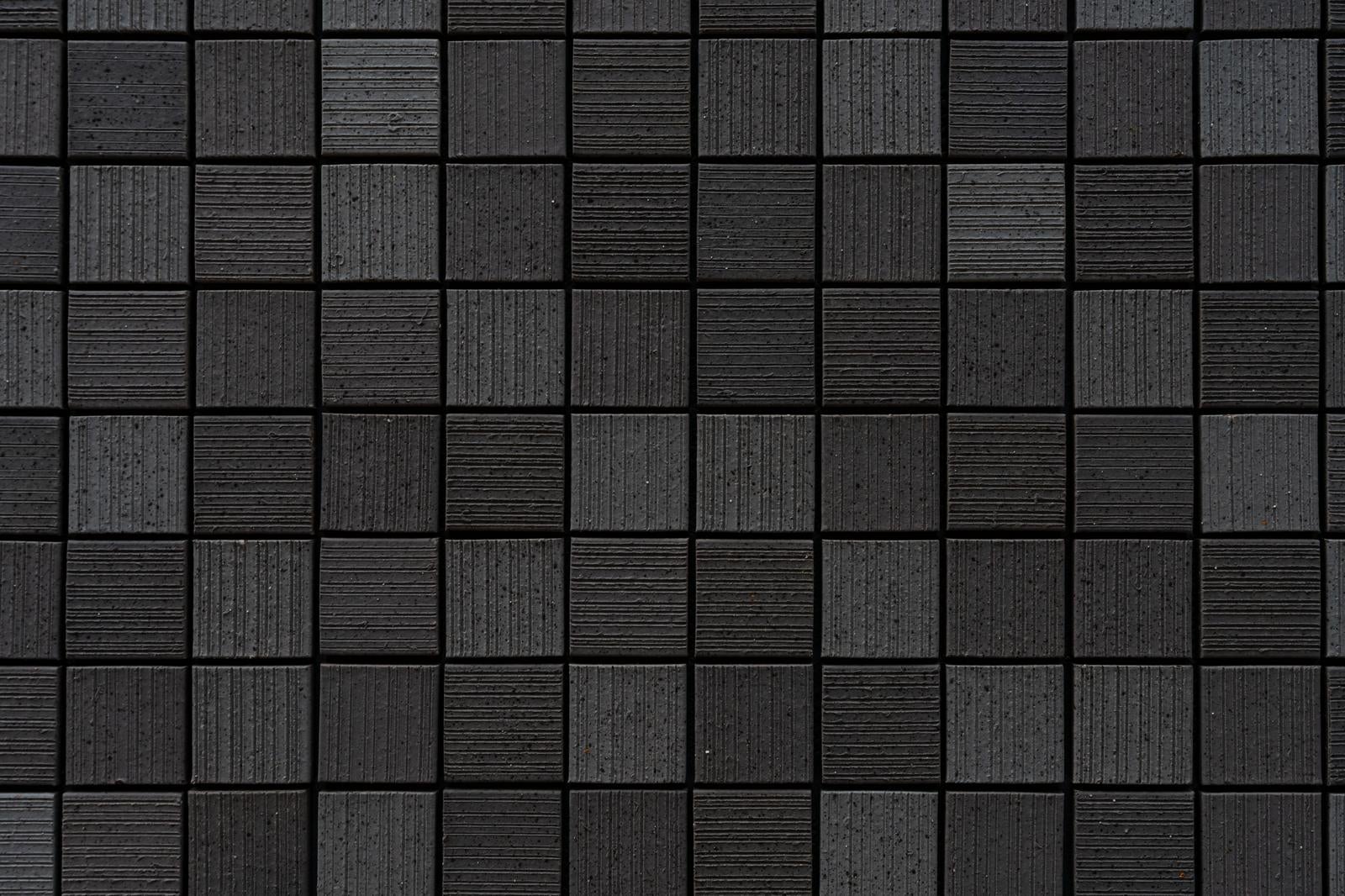 黒いタイルが格子状に配置された幾何学パターンのテクスチャ