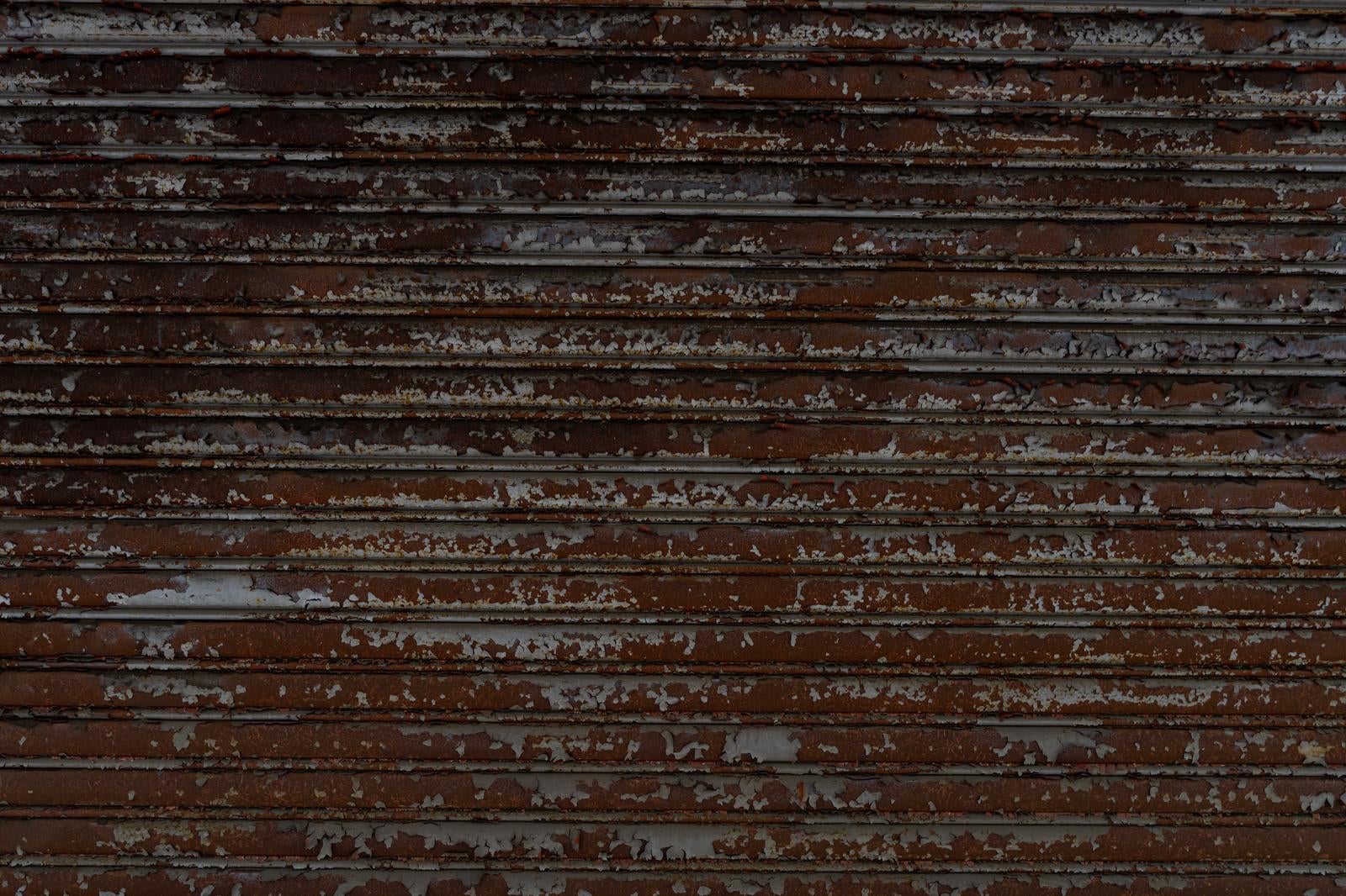 茶色いペンキが剥がれて劣化した古い横張りの木製板壁のテクスチャ