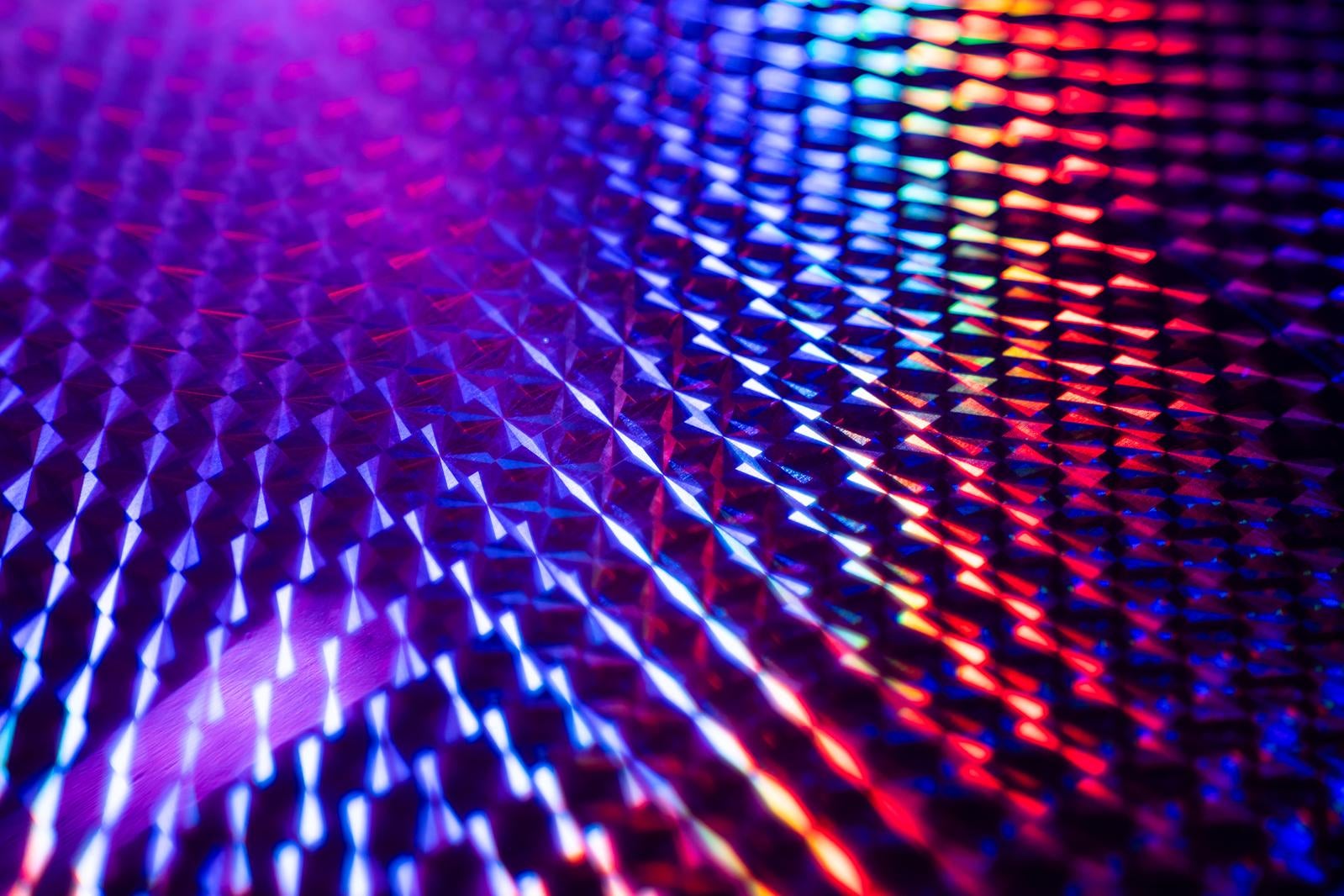 光を反射して虹色に輝くホログラムシートの表面を接写した写真