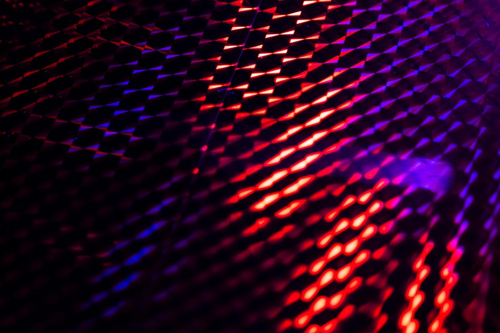 赤紫のネオン光が斜線状に配列して立体的に発光するホログラフィック