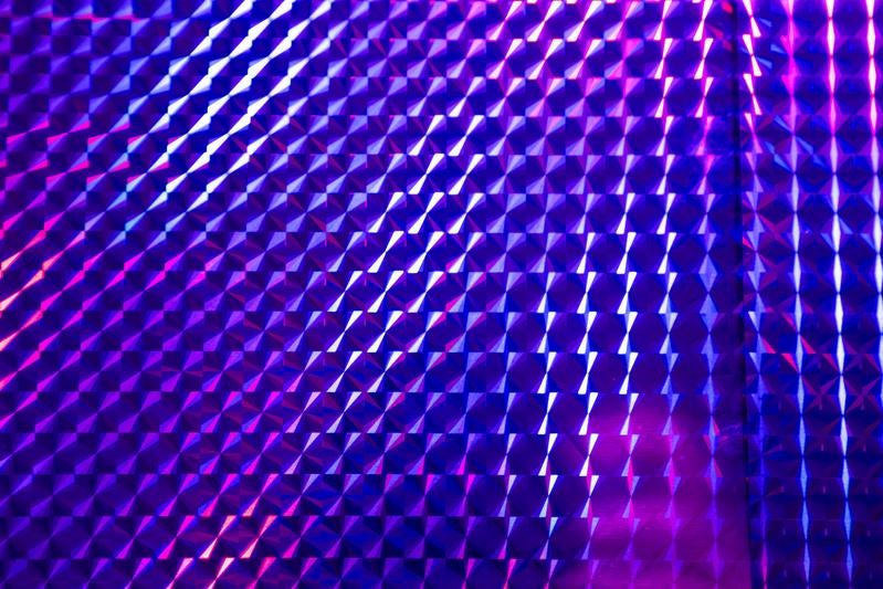 紫とピンクに光る立体的な格子状の3D背景