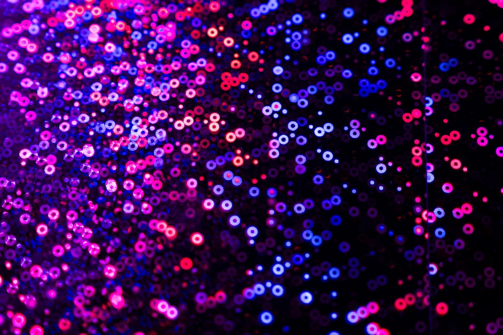 ピンク・青・紫のキラキラ発光球体が黒背景に浮遊する