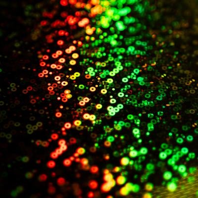 赤から緑へグラデーションする無数のキラキラした円形ボケの光の写真