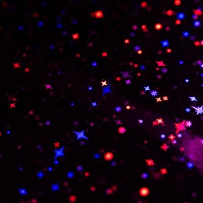 黒背景に赤と青に光るキラキラした星の粒子表現と輝きの背景の写真