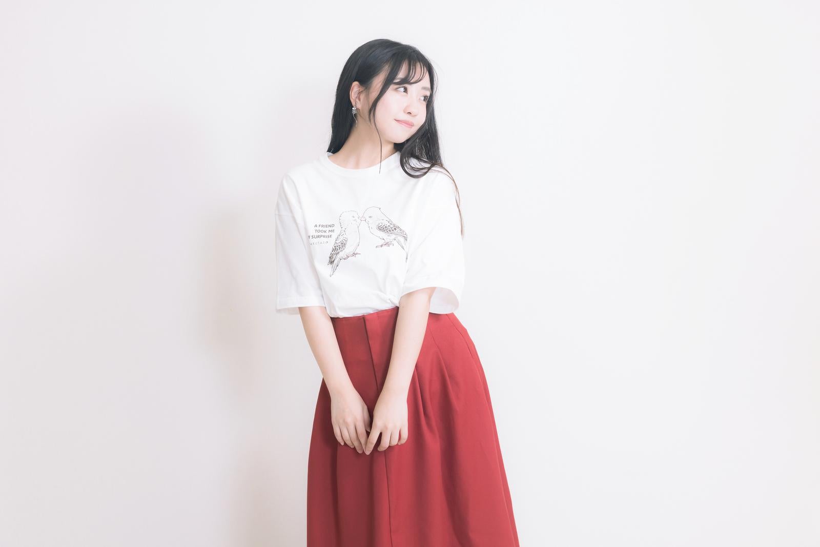 「白いTシャツと赤いロングスカートを着た女性」の写真［モデル：河村友歌］