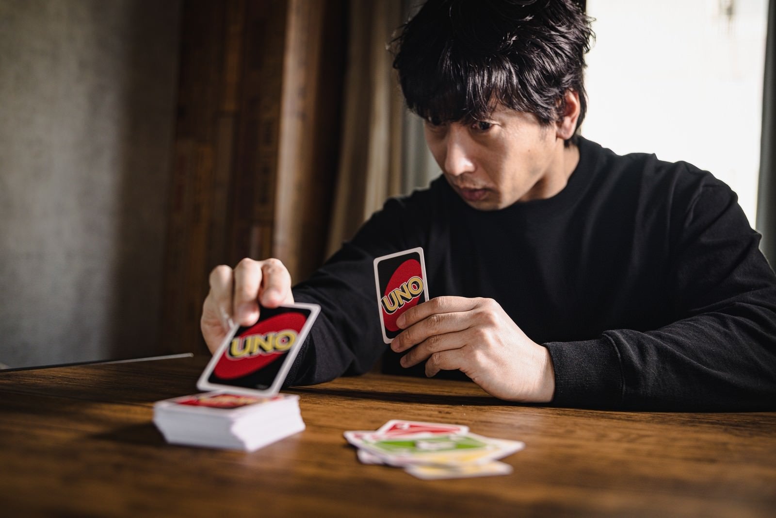 「カードを引く時に、いちいち絞る男性」の写真［モデル：大川竜弥］
