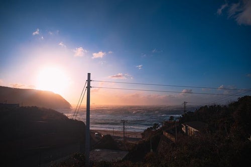 日が沈む神津島の海と荒波の写真