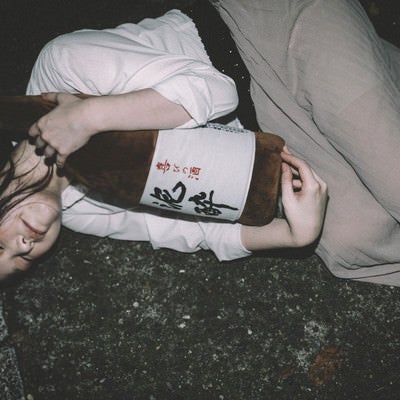 ［忘年会シーズン］泥酔して一升瓶を抱きながら路上で寝てしまった女性の写真