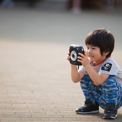 インスタントカメラに興味津々の子供の写真