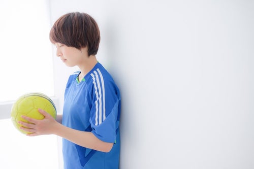 ボールに願いを込めるサッカー女子の写真