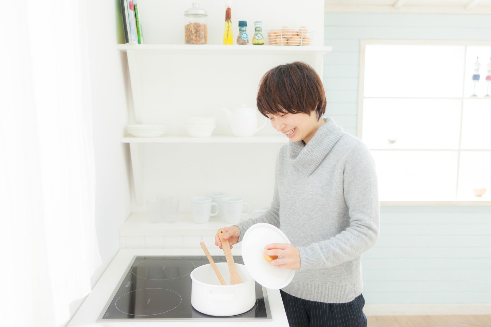 「キッチンでスープを温めなおしている女性」の写真［モデル：八木彩香］