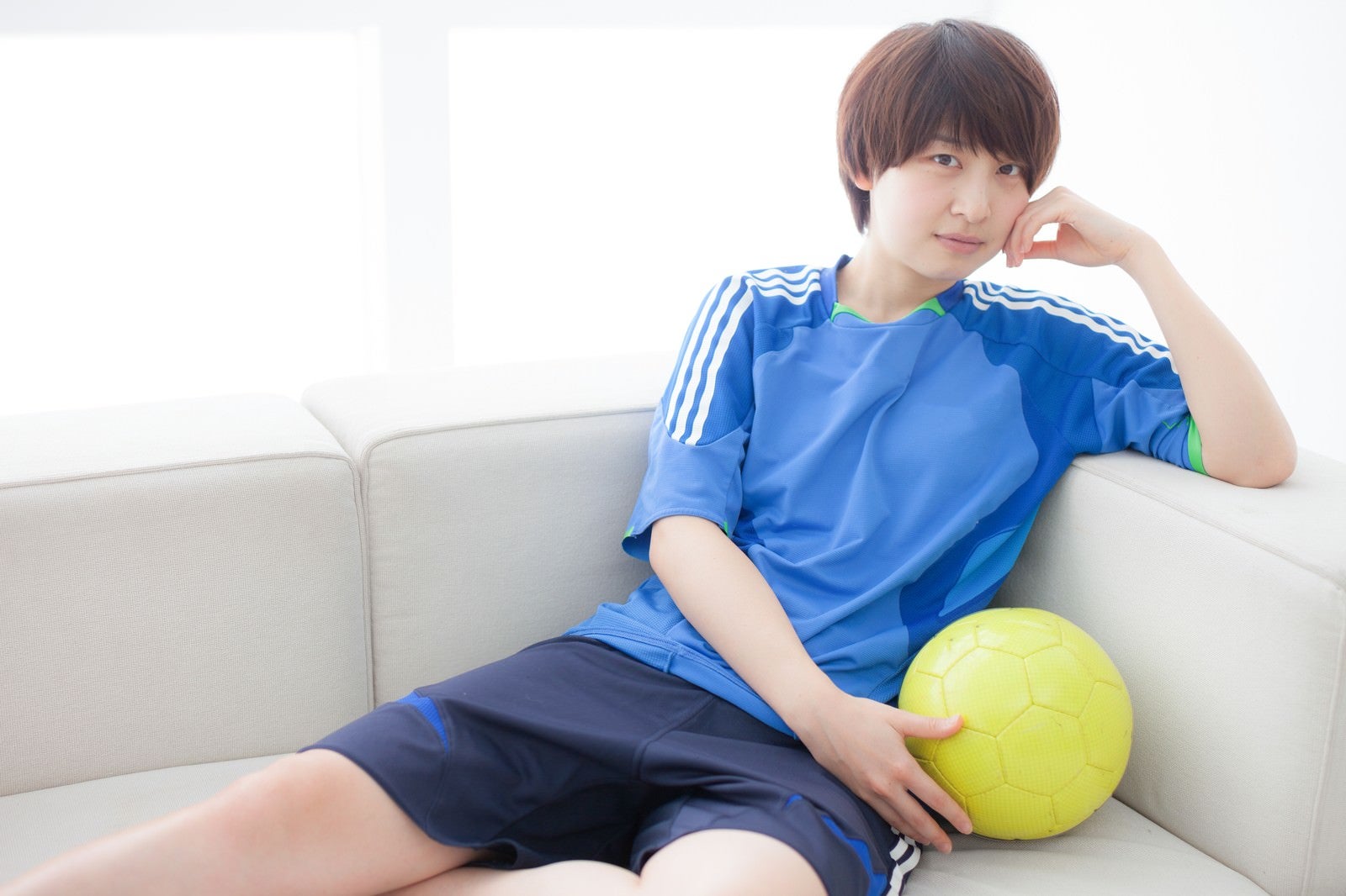 「ソファーでくつろぐサッカー女子」の写真［モデル：八木彩香］