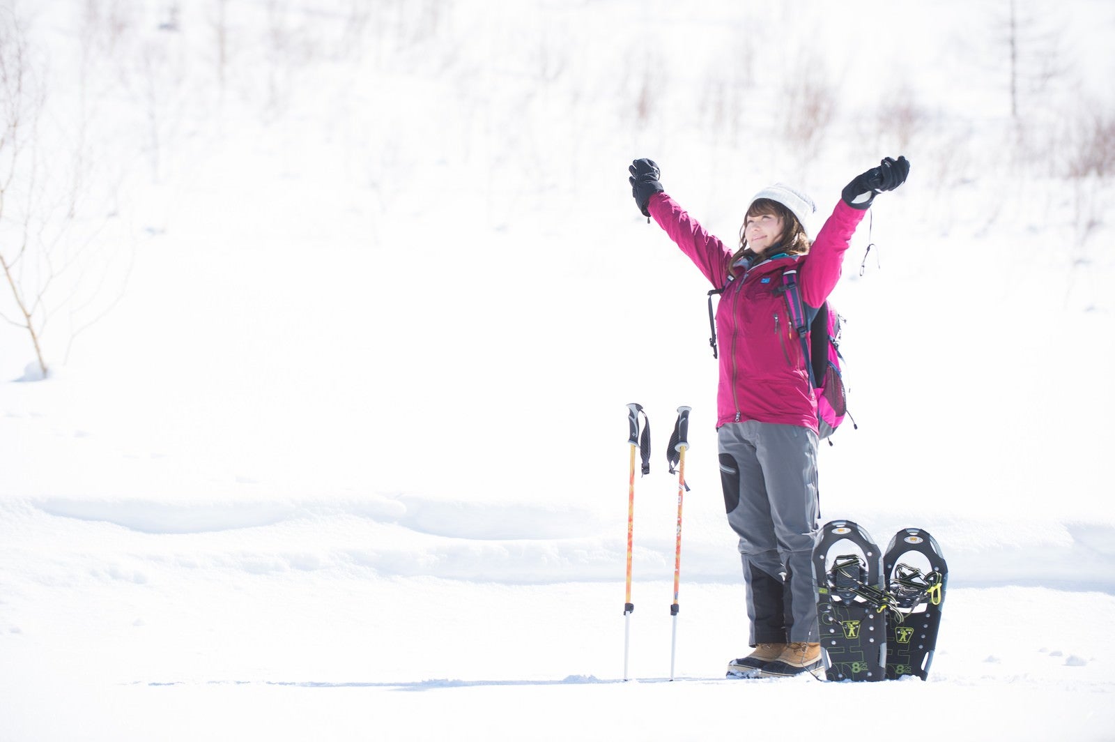 「雪山のトレッキングで大きく伸びをする女性」の写真［モデル：茜さや］