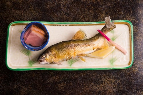 奥飛騨の渓流で釣れる魚を絶妙な塩加減で焼き上げる栄太郎の夕食の写真