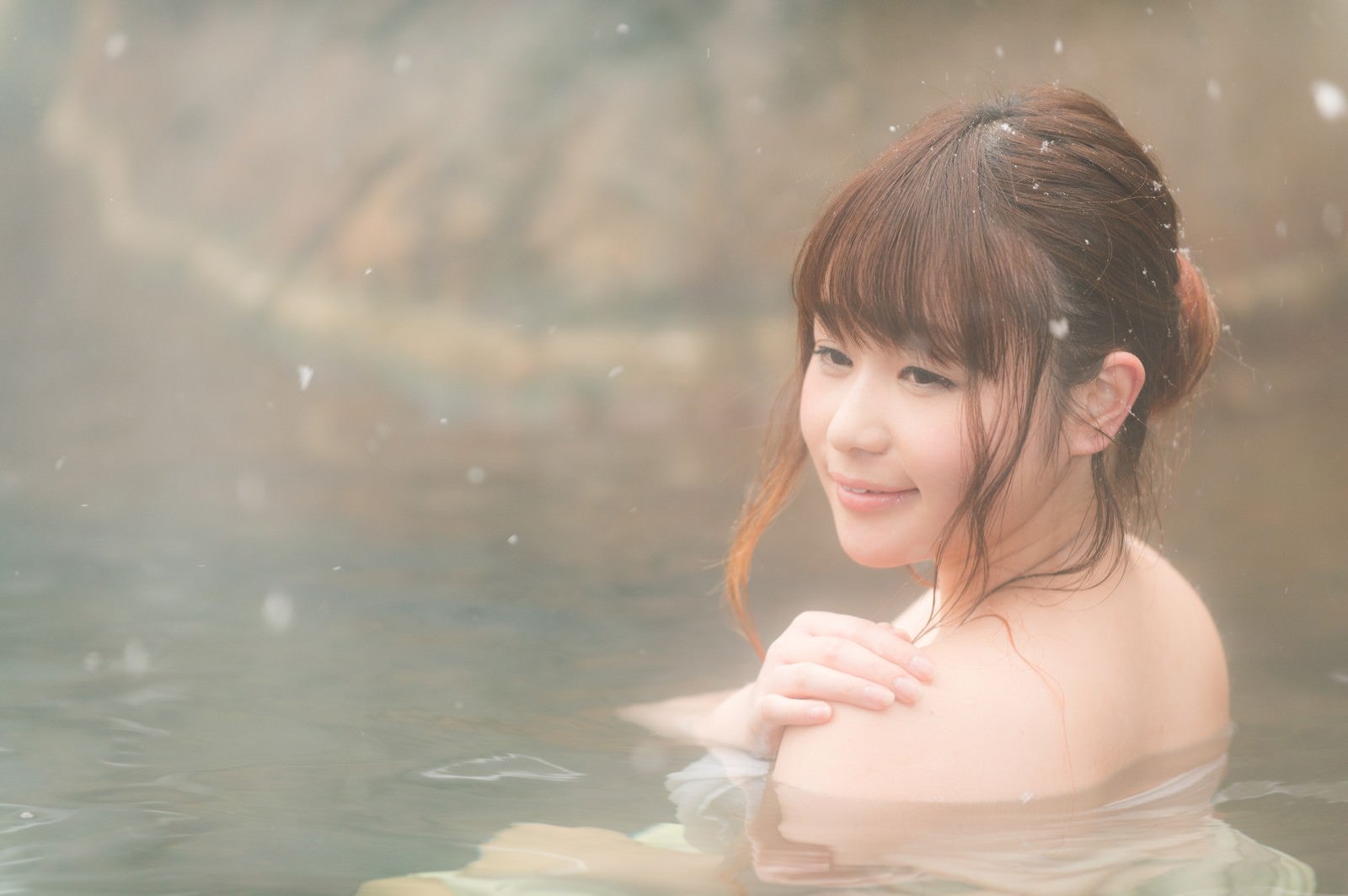 「雪が舞う露天風呂に浸かる美女の透き通る肌」の写真［モデル：茜さや］