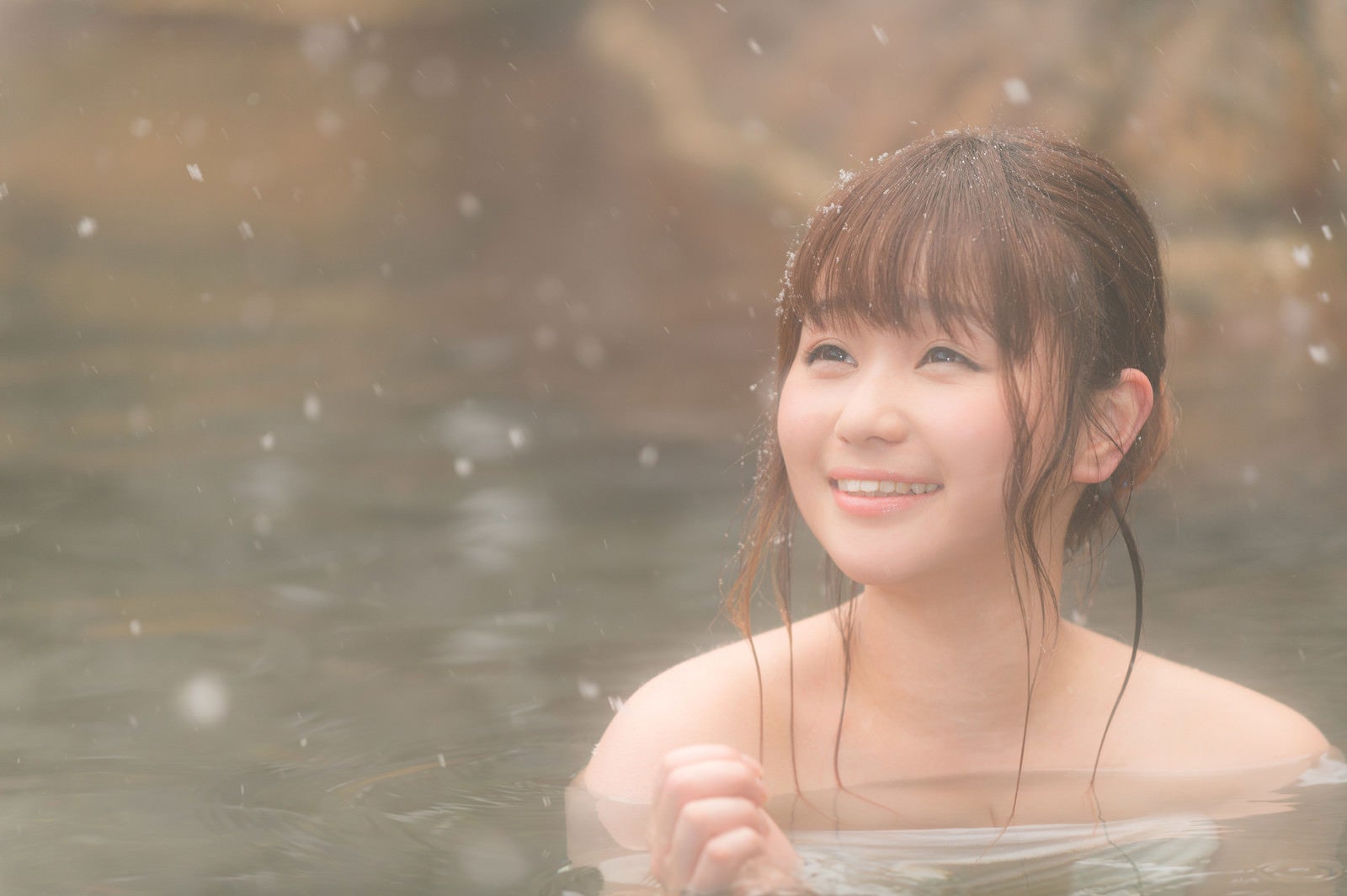 「露天風呂から降雪を楽しむ女性」の写真［モデル：茜さや］