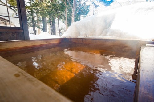 北アルプスの温泉地は雪を眺めながら源泉かけ流しの足湯の写真