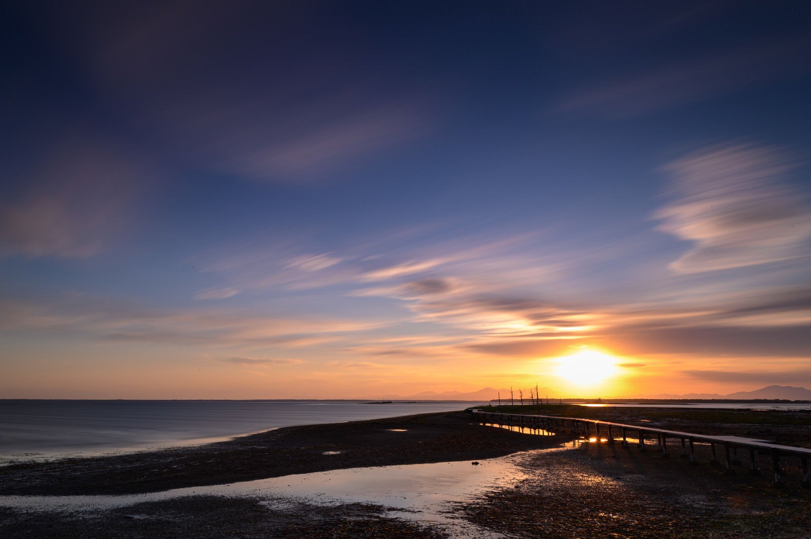 「野付半島の沈む夕日と桟橋」の写真
