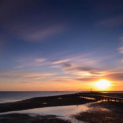 野付半島の沈む夕日と桟橋の写真