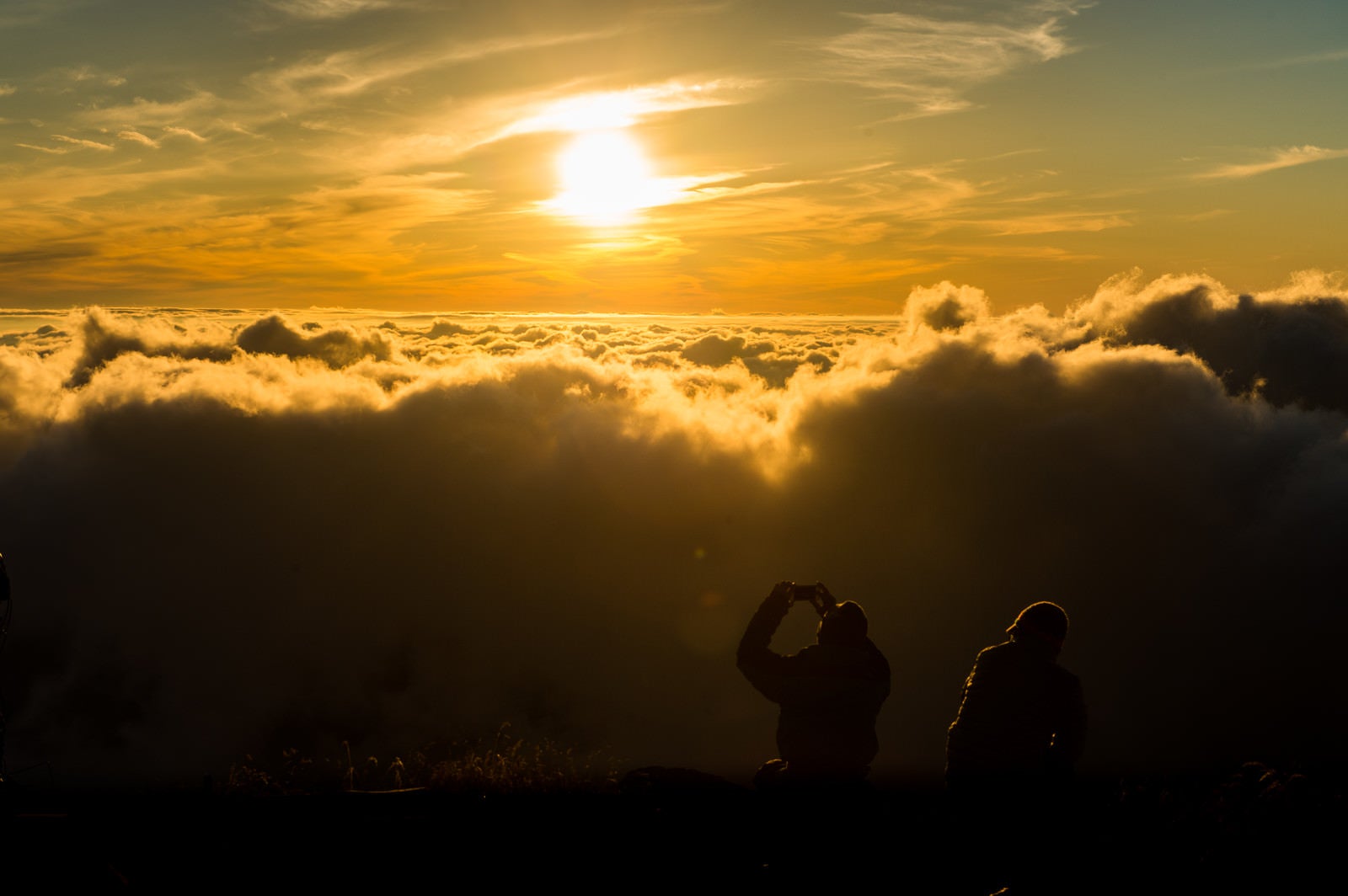「夕暮れの雲海の絶景に感動するカップル」の写真