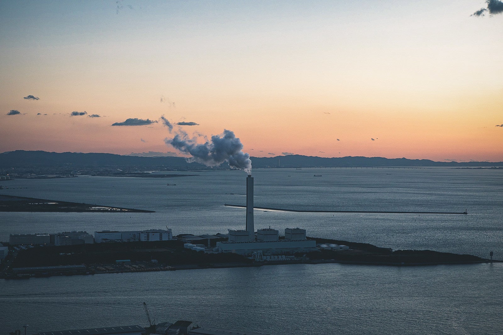 「コスモタワーから見た夕焼けと発電所の煙（大阪府咲洲庁舎展望台）」の写真