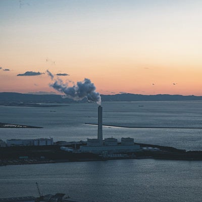 コスモタワーから見た夕焼けと発電所の煙（大阪府咲洲庁舎展望台）の写真