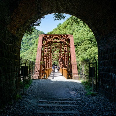 トンネルから見た赤い鉄道橋（JR福知山線廃線敷）の写真