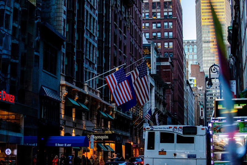 ニューヨークの街並みとアメリカ国旗の写真