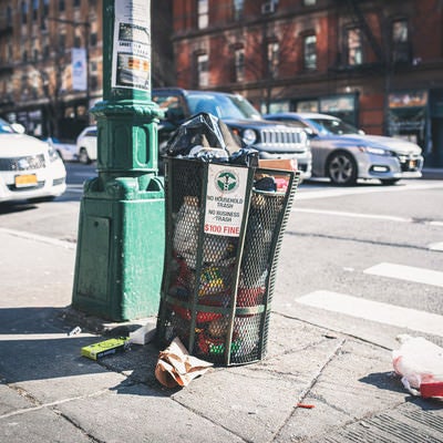 ニューヨークの街角のゴミ箱と散乱するゴミの写真